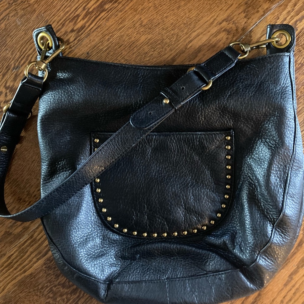 The Sak black leather  hobo bag/purse with brass accents.